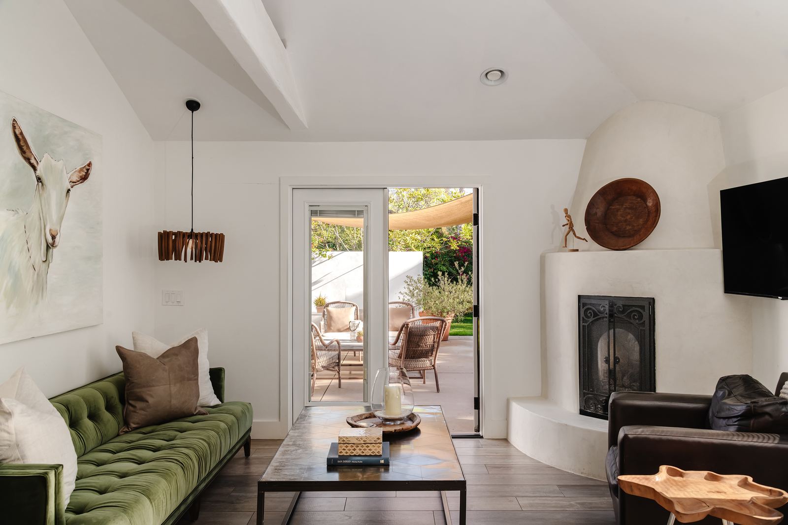 Living room with sofa, fireplace, and view to patio